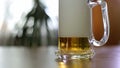 Beer is poured to half empty mug on table