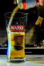 Beer pouring from can into glass on blurred kitchen