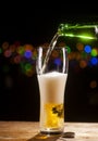 Beer is pouring into glass on bar lights background Royalty Free Stock Photo