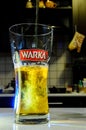 Beer pouring into glass on blurred kitchen