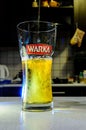 Beer pouring into glass on blurred kitchen