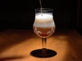 Beer pours into a mug against the background of a dark wooden countertop Royalty Free Stock Photo