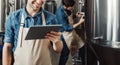 Beer production process at brewery. Man operating brewing equipment at beer making factory and using digital tablet Royalty Free Stock Photo