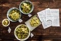 Beer Recipe and Whole Dried Hops ready to be Pitched in the Kettle of a Homebrewer. Royalty Free Stock Photo