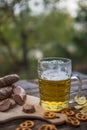 Beer, sausages and pretzels on the wooden board outdoor. October