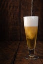 Beer served in a glass with rustic wood background Royalty Free Stock Photo