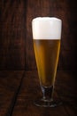 Beer served in a glass with rustic wood background Royalty Free Stock Photo