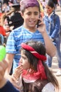 Beer-Sheva, ISRAEL - March 5, 2015: Teenager boy with purple hair dyed in a blue striped shirt with mobile phone -Purim Royalty Free Stock Photo