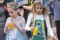 Beer-Sheva, ISRAEL - March 5, 2015:Two girls in carnival costumes on the street drinking orange juice -Purim