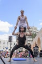 Beer-Sheva, ISRAEL - March 5, 2015: Two men, clowns, gymnasts, one of them in a tutu - with exercises on the open stage Royalty Free Stock Photo