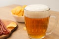 Beer and snack. Beer, Grilled sausage, potato chips on bar table. Beer pub set. Large beer mug with fried sausages Royalty Free Stock Photo