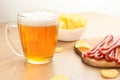 Beer and snack. Beer, Grilled sausage, potato chips on bar table. Beer pub set. Large beer mug with fried sausages Royalty Free Stock Photo