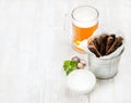 Beer snack set. Pint of pilsener in glass mug and rye bread croutons with garlic cream cheese sauce over white painted Royalty Free Stock Photo