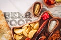 Beer and snack set. Variety of beers, grilled sausages, fried potatoes, salted on wooden background