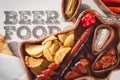 Beer and snack set. Variety of beers, grilled sausages, fried potatoes, salted on wooden background
