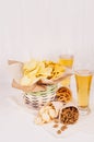 Beer snacks in craft paper and two lager beer in glass on soft fresh wooden table. Royalty Free Stock Photo