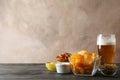 Beer snacks, glass of beer, potato chips, beer nuts, sauces, glass of beer on wooden background