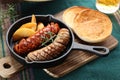 A Glass of Beer and grilled sausage and fried potatoes with muffins Royalty Free Stock Photo