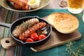 A Glass of Beer and grilled sausage and vegetables with toasted muffins Royalty Free Stock Photo