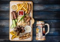 Beer snacks set. Grilled sausages and french fries with tomato and BBQ sauce, served on cutting board with the antique Royalty Free Stock Photo