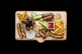 Beer snacks set. Grilled sausages and french fries with tomato and BBQ sauce, served on cutting board. Royalty Free Stock Photo