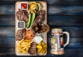 Beer snacks set. Meat set served on cutting board with the antique mug, on the wooden background. Royalty Free Stock Photo