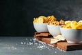 Beer snacks on stone table. Various crackers, potato chips. Top view. Creative photo.