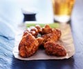 Beer and spicy boneless chicken wings on slate Royalty Free Stock Photo