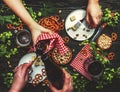 Beer summer party: dark and light beer, appetizers, salty snacks, hop cones, plates and glasses in the hands of people. Top view, Royalty Free Stock Photo