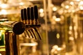 Beer taps to dispense beer in mug with selective focus and distillery in background of a brewery Royalty Free Stock Photo