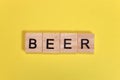 Beer word from wooden letters on yellow background