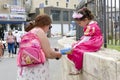 Beersheba, Israel. March 24, Mom shoes a girl in a carnival dress on the street in Purim