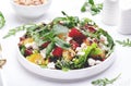 Beet, cheese and orange healthy salad with arugula, lamb lettuce, mini chard and pistachios, white kitchen table, copy space..