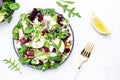 Beet, feta cheese and pear healthy salad with arugula, lamb lettuce, red onion, chard and walnut, white kitchen table. Fresh Royalty Free Stock Photo