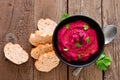 Beet hummus dip, above view table scene with bread over wood