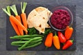 Beet hummus vegetable platter, above view on slate