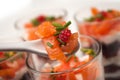 Beet and salmon appetizers in little glasses on white background