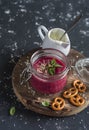 Beet soup in glass jar on wooden chopping board on a dark background. Royalty Free Stock Photo