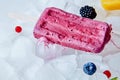 Beet vanilla yogurt popsicle over the ice with berries , flat lay Royalty Free Stock Photo
