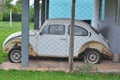 Beetle, old semi-destroyed vehicle in white color with light alloy wheels in a farm garage i Royalty Free Stock Photo