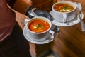 Beetroot and cabbage soup, borshch. Waiter serving dinner at restaurant or diner, eating out concept Royalty Free Stock Photo