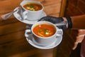 Beetroot and cabbage soup, borshch. Waiter serving dinner at restaurant or diner, eating out concept Royalty Free Stock Photo