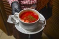 Beetroot and cabbage soup, borshch. Waiter serving dinner at restaurant or diner, eating out concept Royalty Free Stock Photo