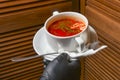 Beetroot and cabbage soup, borshch. Waiter serving dinner at restaurant or diner, eating out concept Royalty Free Stock Photo