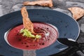 Beetroot cream soup with celery and croutons in plate on dark grey background with spoon and napkin. Healthy vegan food Royalty Free Stock Photo