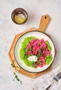 Beetroot dumplings or gnocchi with mashed green peas and curd cheese in a white plate on a light concrete background. Vegetarian Royalty Free Stock Photo