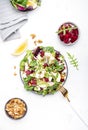 Beetroot, feta cheese and pear salad with arugula, lettuce, red onion, swiss chard and walnut, white kitchen table. Fresh Royalty Free Stock Photo