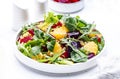Beetroot and orange salad with arugula, lamb lettuce, mini chard and pistachios, white table, copy space.. Fresh useful dish for