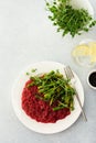 Beetroot risotto with rice and sesame seeds, baked asparagus with microgreens Royalty Free Stock Photo