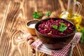 Beetroot salad with wallnuts and garlic in bowl on wooden table